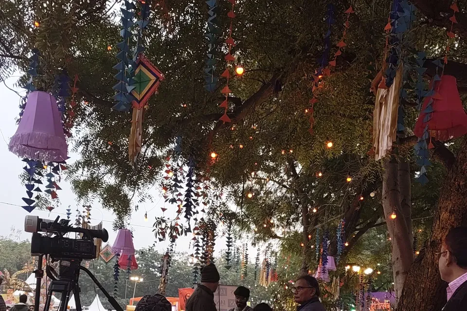Lanterns and festoons strung above the festival grounds at dusk