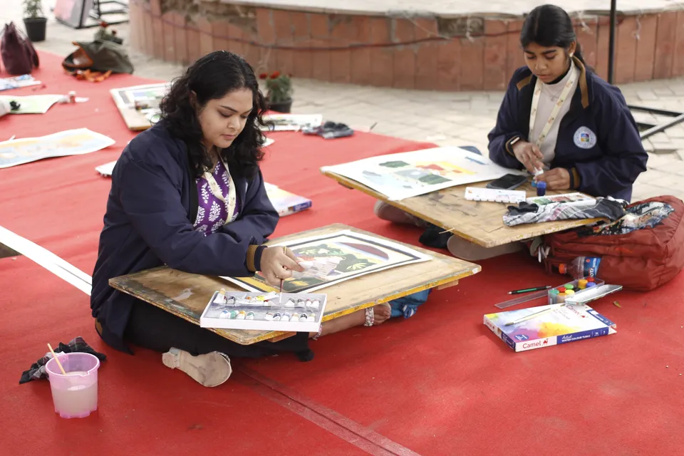 Students paint on the lawns at the art workshop