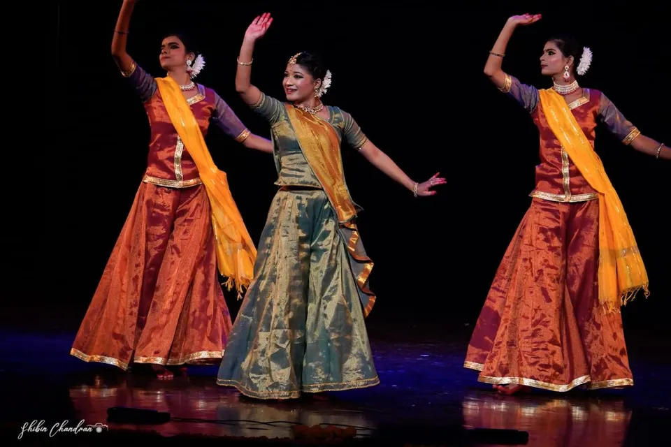Dancers in formation with raised arms