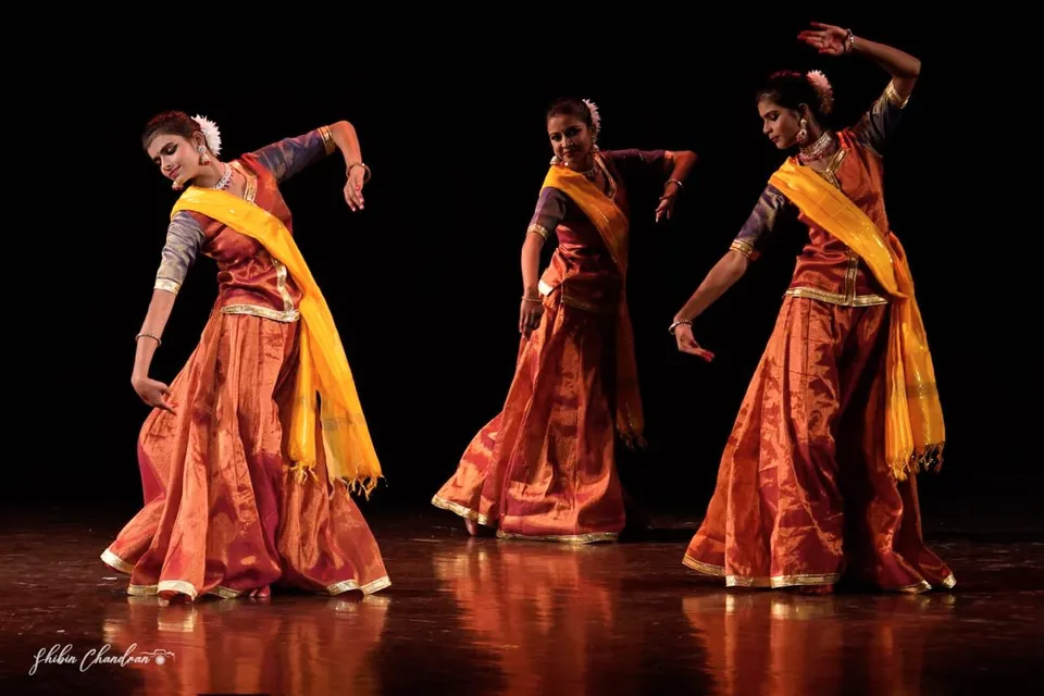 Dancers in saffron and yellow in motion