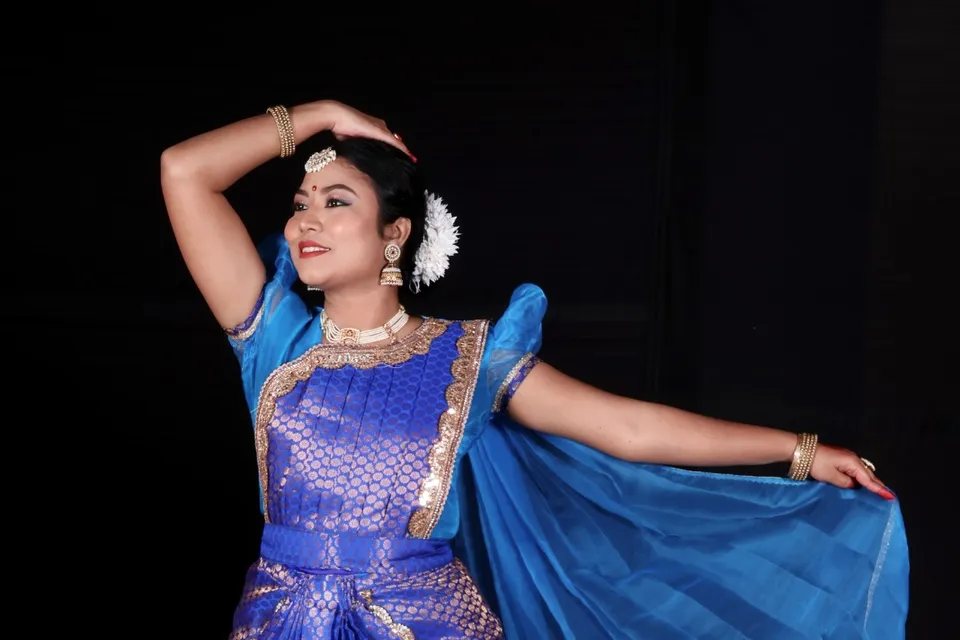 A dancer in blue in a classical pose